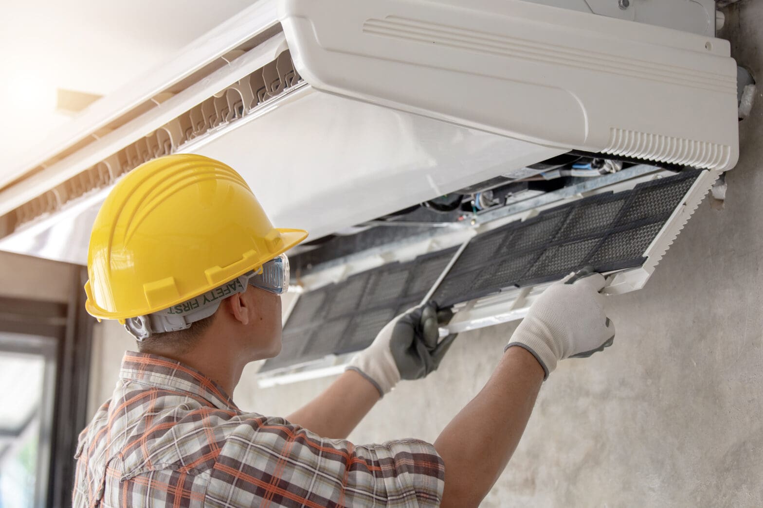 an hvac expert cleaning an air conditioning unit